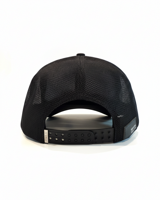 Back view of the RWLS Black snapback mesh cap with a black brim. RWLS engraved metal logo on the left of a dual snap strap. Small Rebellious Wealth leather patch on bottom right side of the hat. Adjustable to fit any head size. rebelliouswealth.com