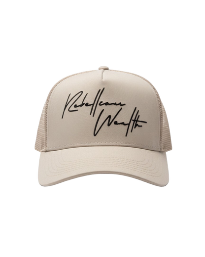 Beige cream color trucker snapback hat with Black 'Rebellious Wealth' signature script text logo on the front panel. Mesh side panels. rebelliouswealth.com 