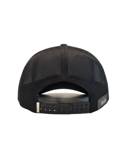 Back view of the Black RWLS trucker snapback hat Signature series. Black mesh side and back panels. Chrome engraved logo on a dual snap strap. Rebellious Wealth leather logo patch sewn on the bottom right. rebelliouswealth.com