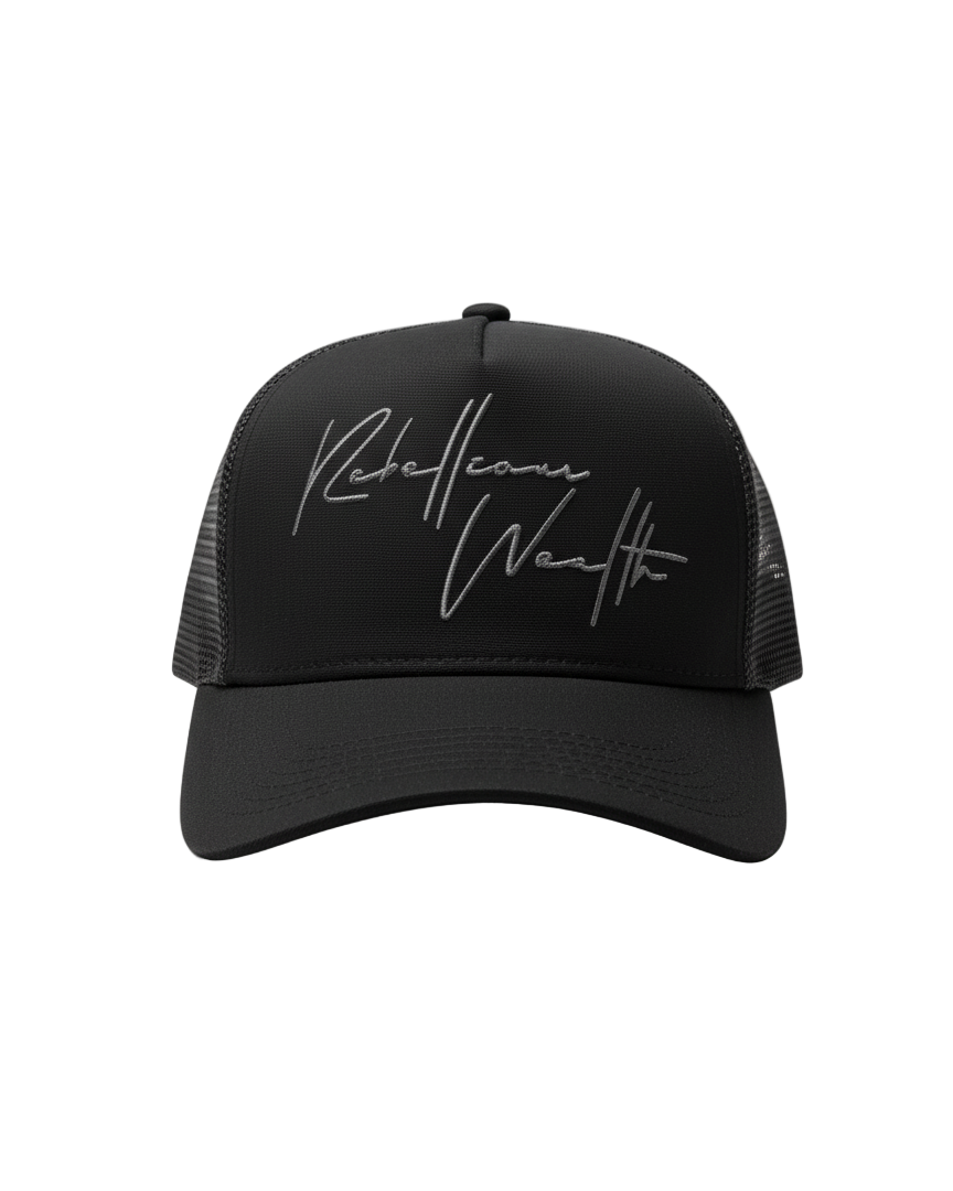Front view of the Black Rebellious Wealth trucker snapback hat with a gray "Rebellious Wealth" signature on the front panel. Mesh side panels and dual snapback strap. rebelliouswealth.com