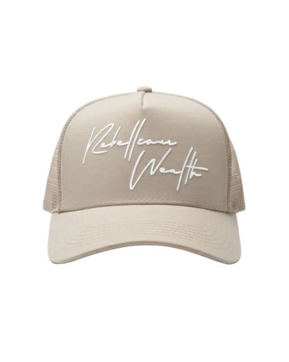 Beige cream color trucker hat with white 'Rebellious Wealth' signature script text logo on the front panel. Mesh side panels. rebelliouswealth.com