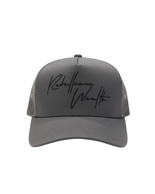 Stone Gray Rebellious Wealth trucker hat with a black "Rebellious Wealth signature on the front panel. Mesh side panels and dual snapback strap. rebelliouswealth.com